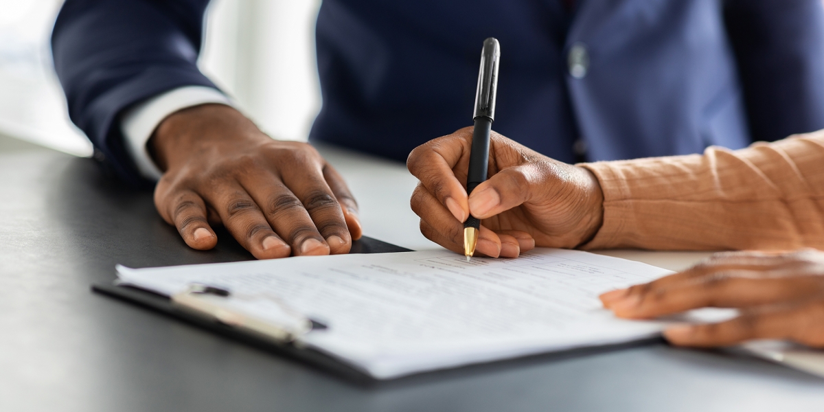 Peoples hands signing a contract