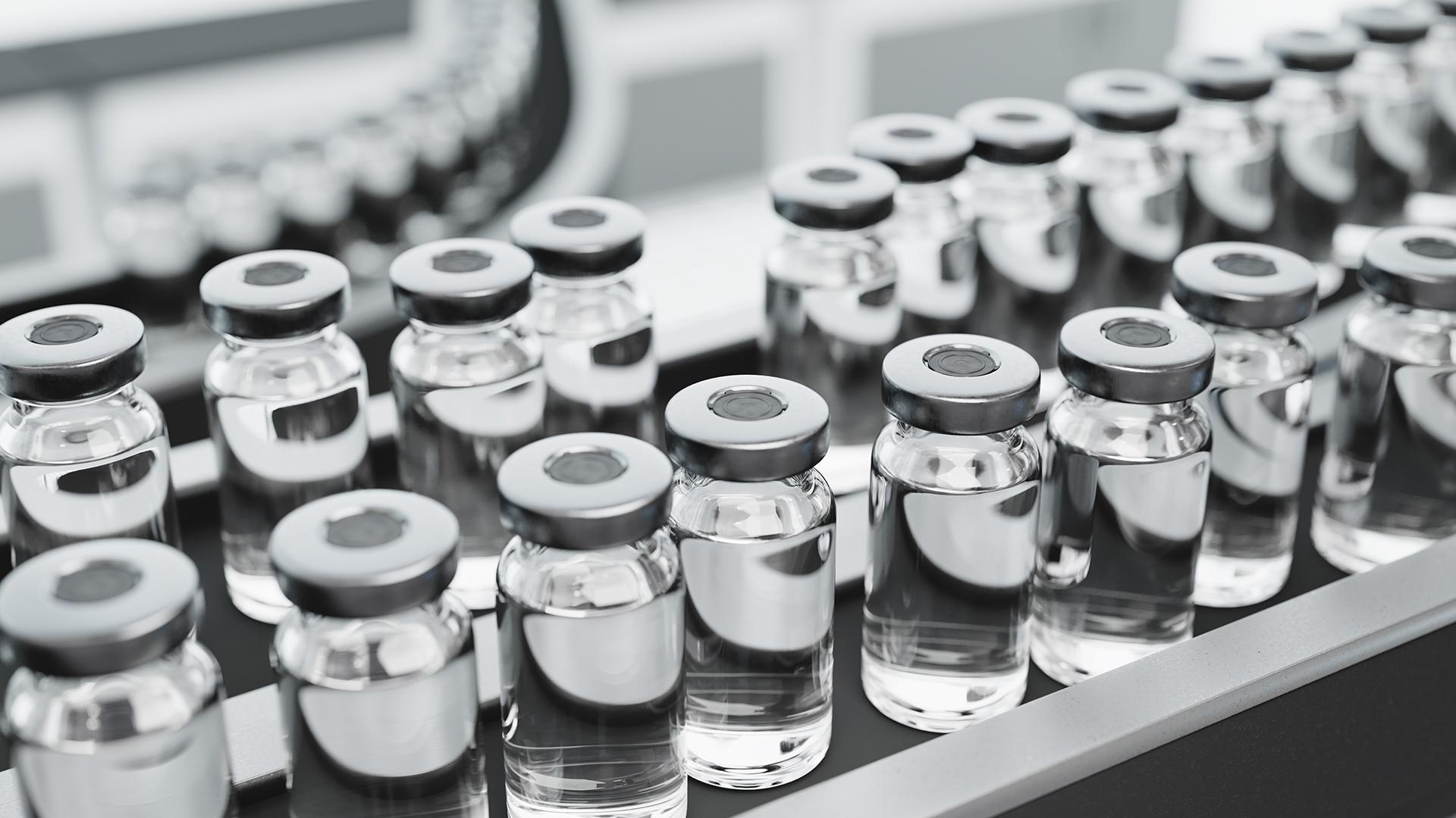 Vials of vaccine medication on an assembly line.