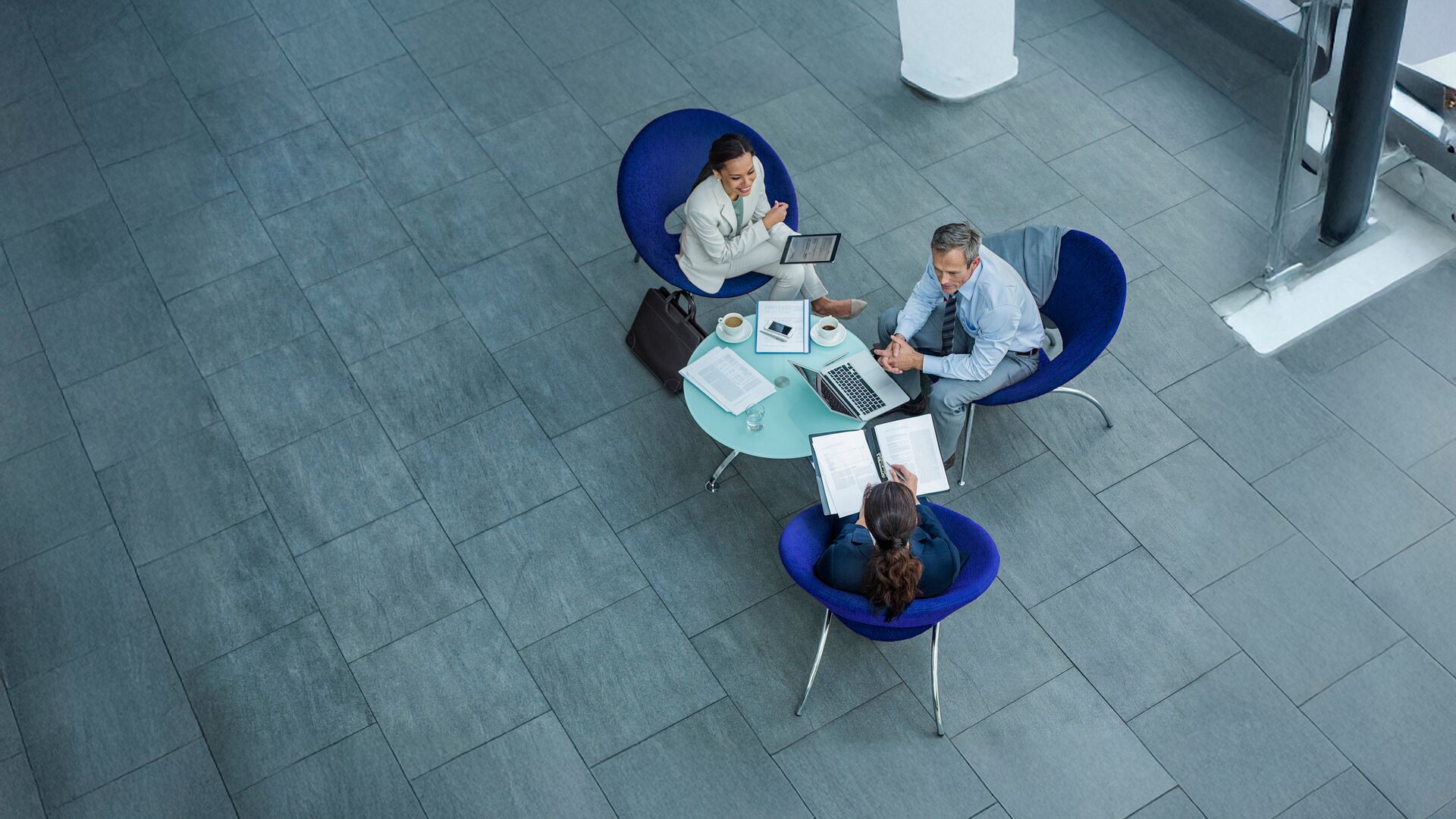 High angle view of businesspeople discussing strategy at coffee table in office