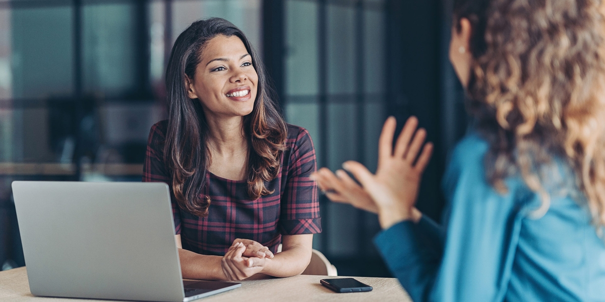 Two women speaking together at a table