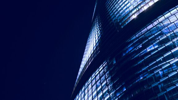 A modern looking skyscraper during the nighttime.