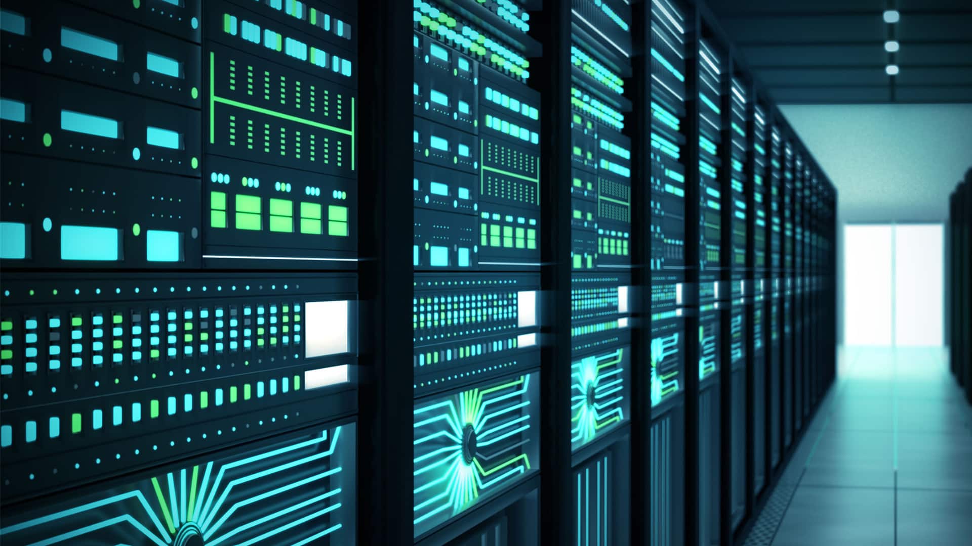 A row full of floor to ceiling computer servers in a dark room.