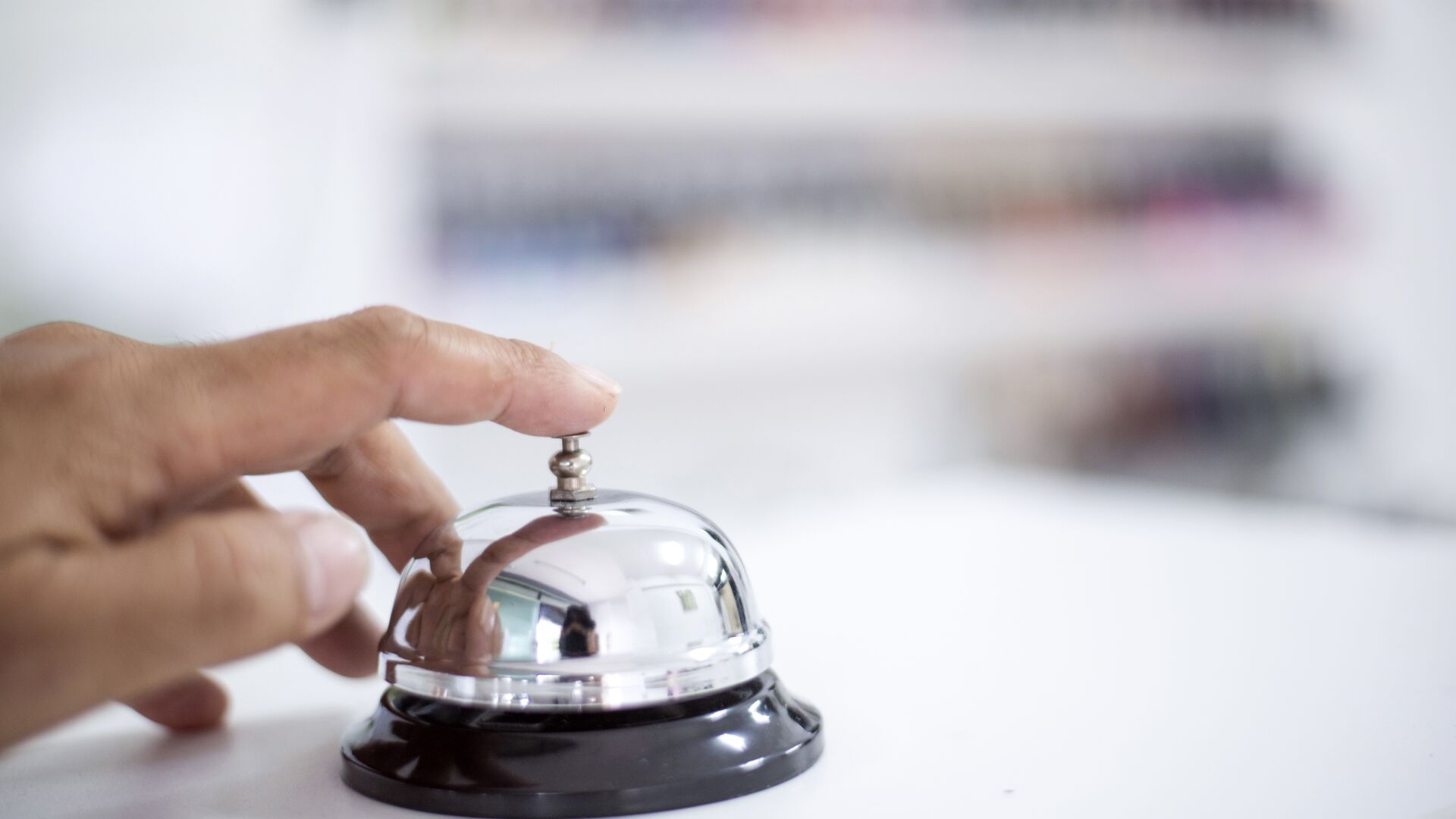 A hotel desk bell on a marble counter top.